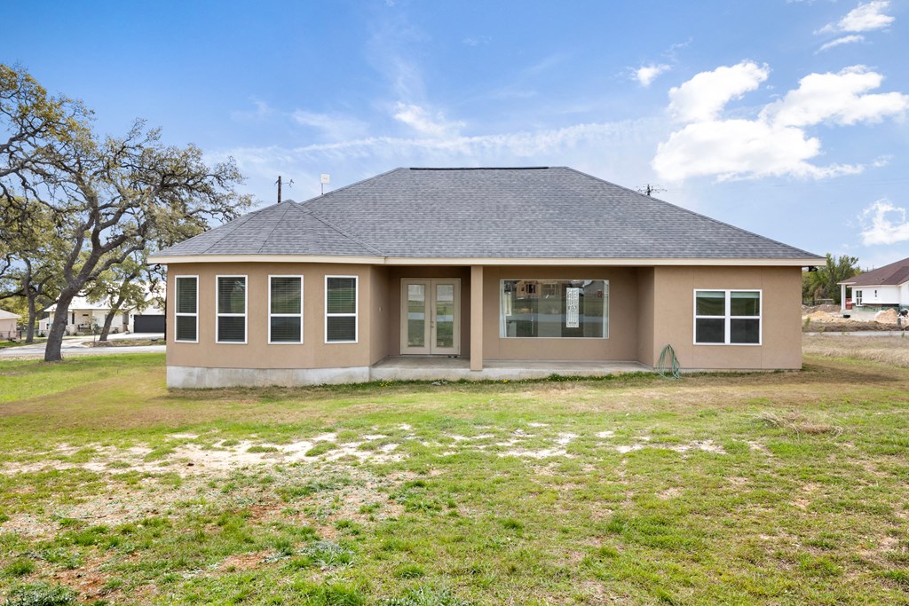 a home with a gray roof and a yard with grass