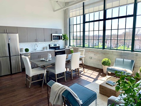 A kitchen with a table and chairs in front of a window.