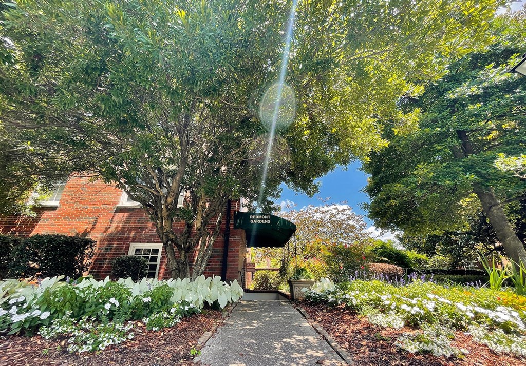 a garden in front of a brick building