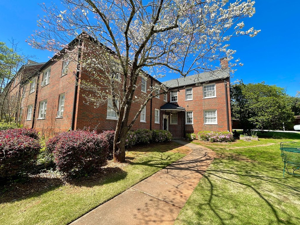 an old brick building with a sidewalk in front of it
