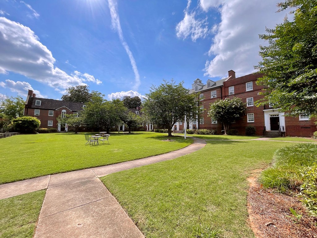 a large lawn in front of a brick building
