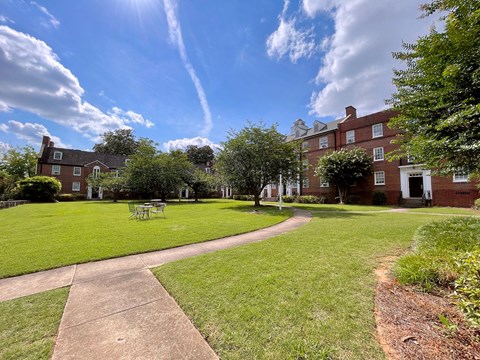 a large lawn in front of a brick building