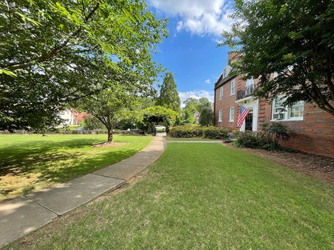 a sidewalk in front of a brick house