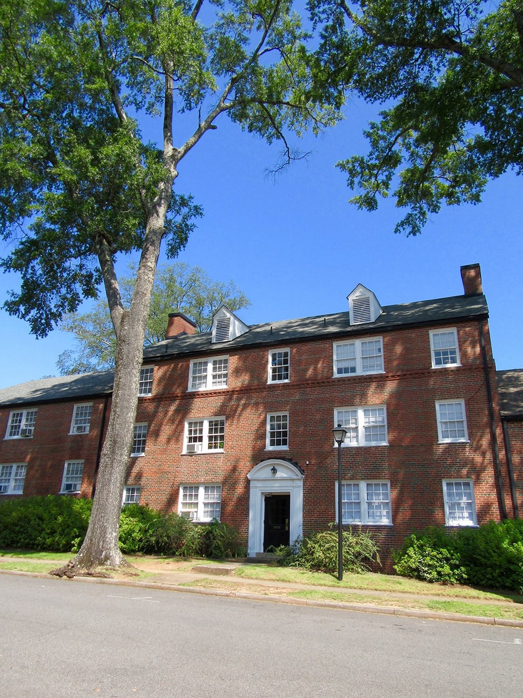 a red brick building with a tree in front of it