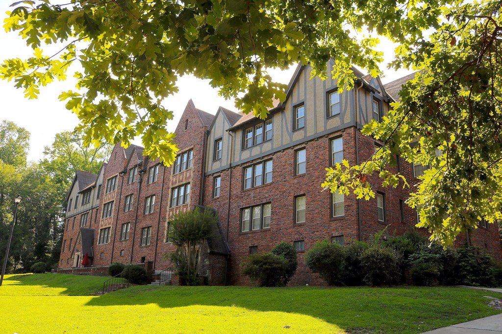 a large brick building with a lawn in front of it