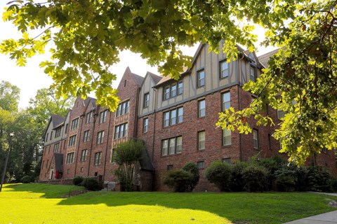 a large brick building with a lawn in front of it