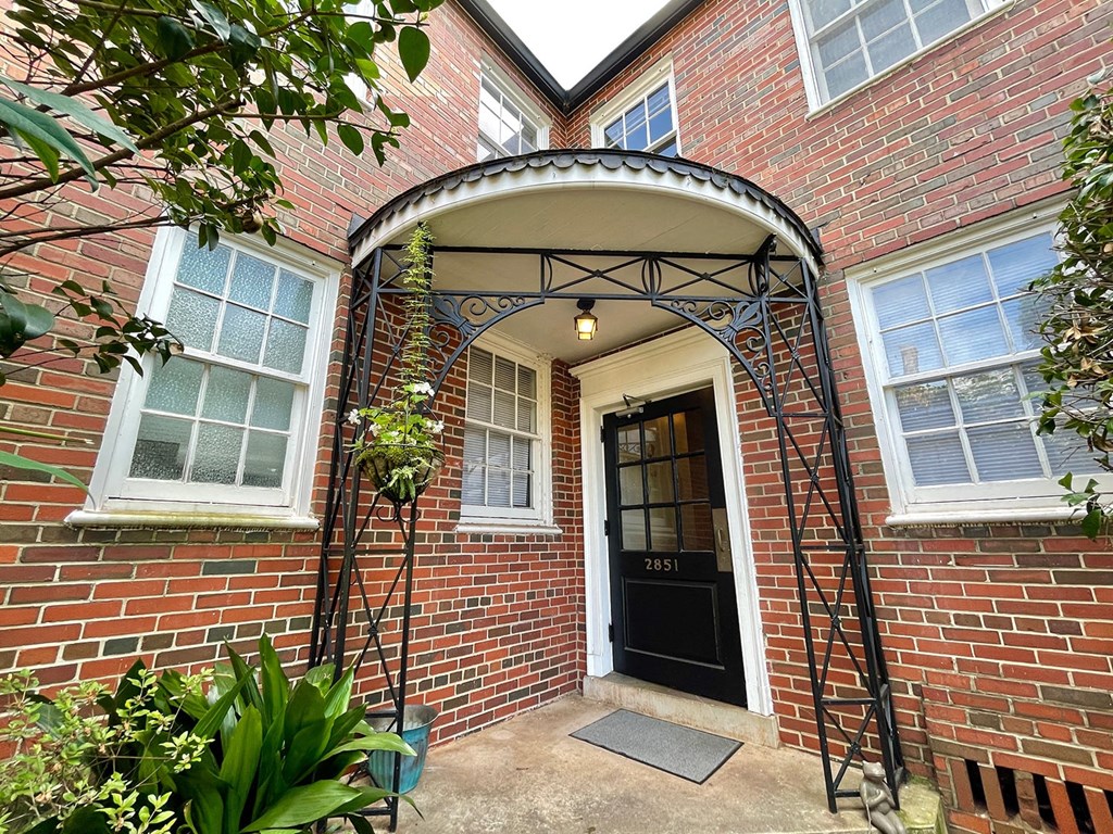 the front entrance of a brick house with a black door