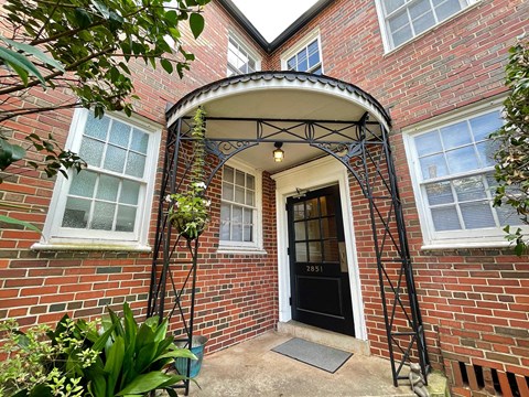 the front entrance of a brick house with a black door