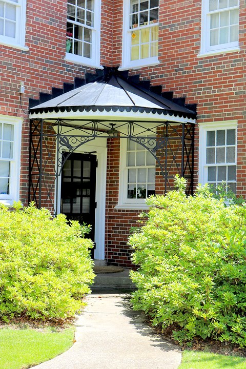 the front of a brick house with a black door