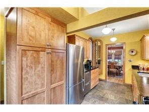 a kitchen with wooden cabinets and a stainless steel refrigerator