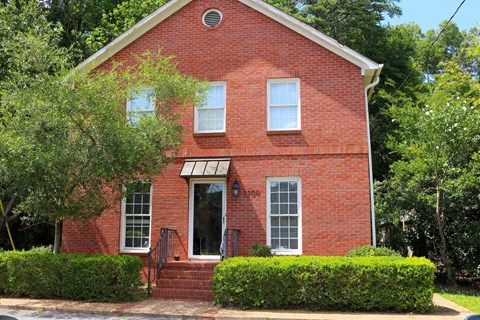 a red brick church with a tree in front of it