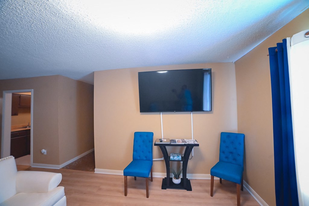 a living room with a table and chairs and a television
