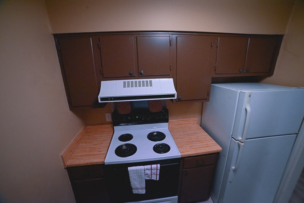 a small kitchen with a stove and a refrigerator
