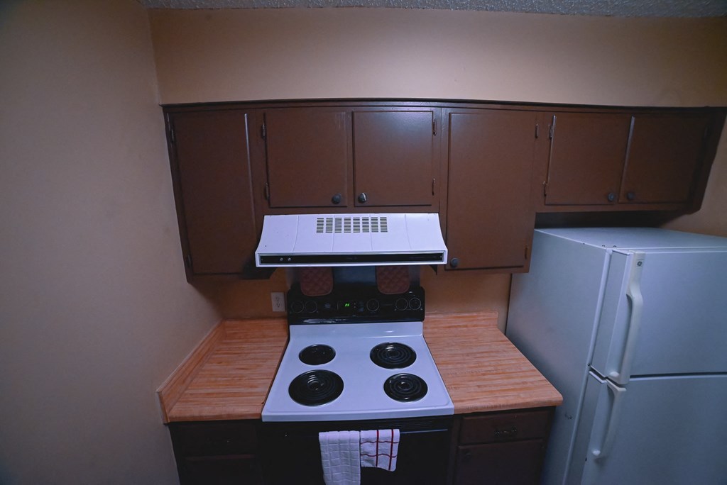 a small kitchen with a stove and a refrigerator