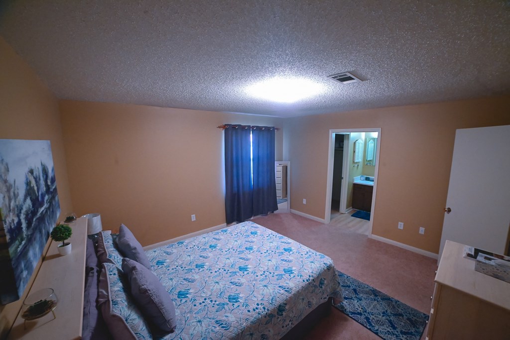 a bedroom with a large bed and a blue curtain