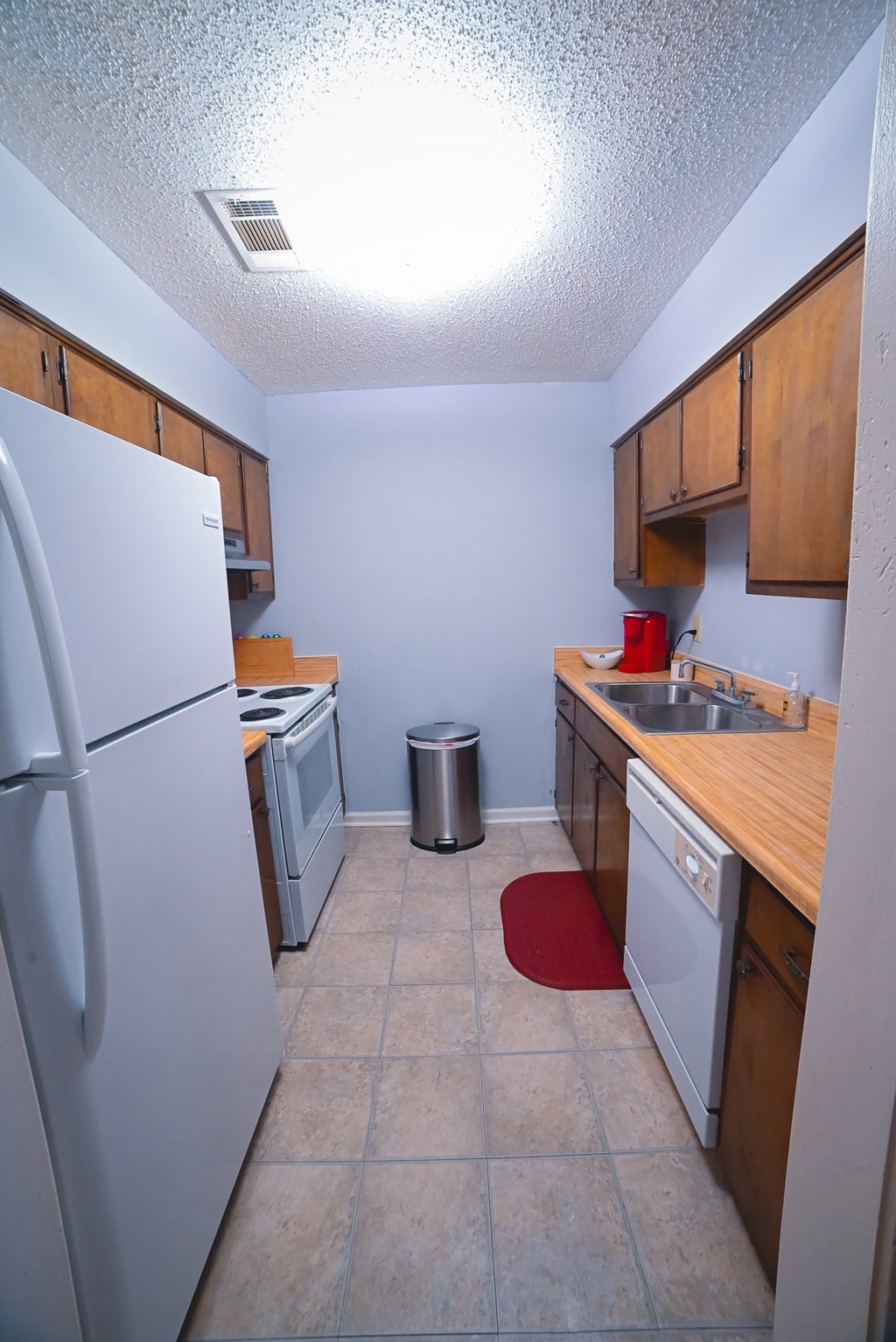 a kitchen with a refrigerator sink and dishwasher and a refrigerator and counter top