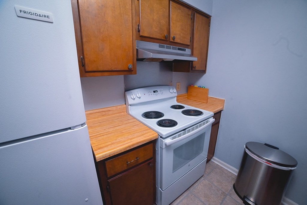 an empty kitchen with a stove and a refrigerator