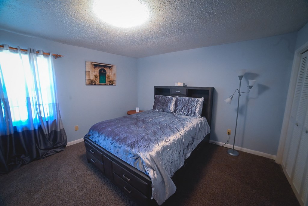 a bedroom with a bed and a window