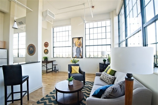 A living room with a grey couch and a black chair.
