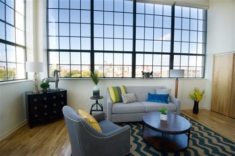A living room with a grey couch, a black dresser, and a coffee table.