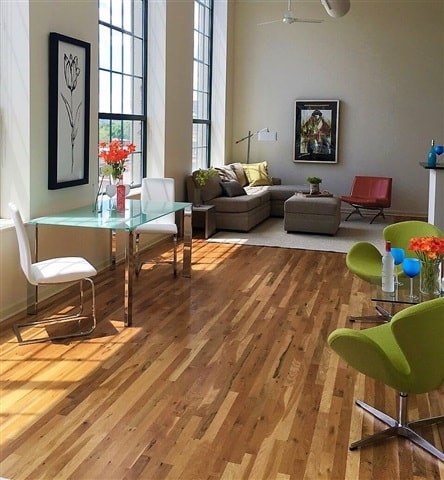 A living room with a glass table and a green chair.