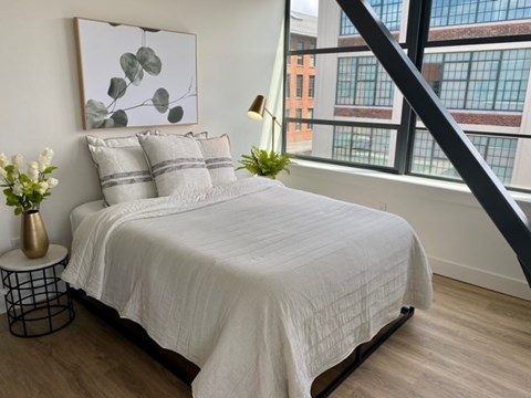 a bedroom with a bed and a large window