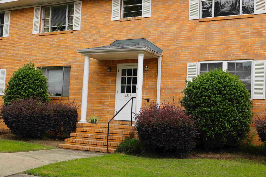 the front of a brick house with a white door