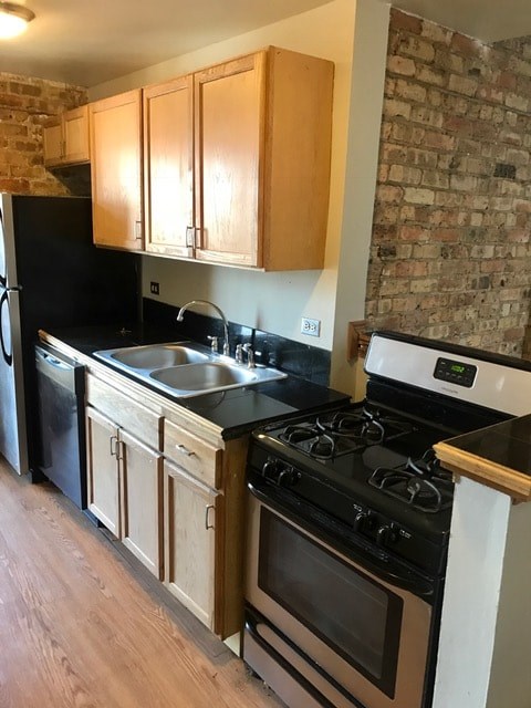 A kitchen with wooden cabinets and a black fridge.