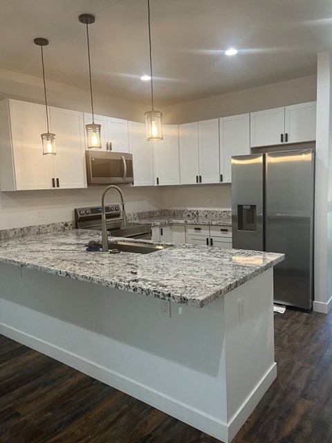 a kitchen with white cabinets and a granite counter top