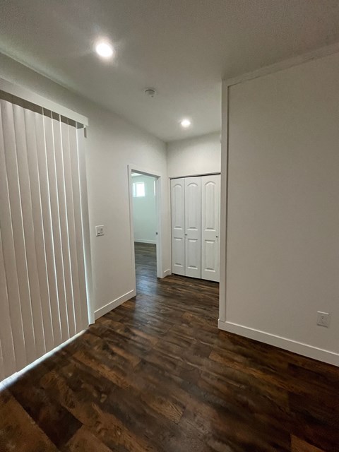 a living room with white walls and wood floors