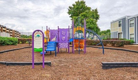 a playground with a purple and orange swing set