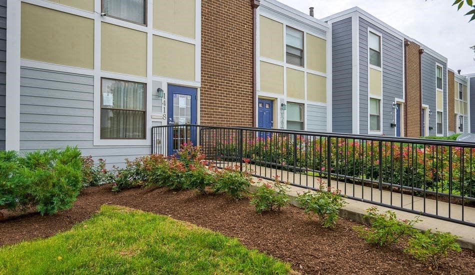 an apartment building with a garden in front of it