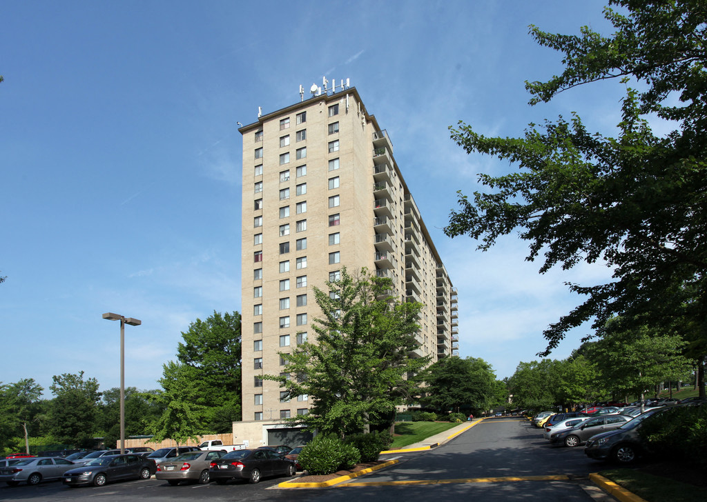 A tall building with a parking lot in front of it.