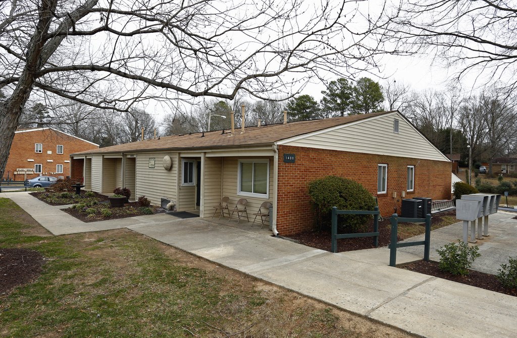 a small white house with a porch and a sidewalk