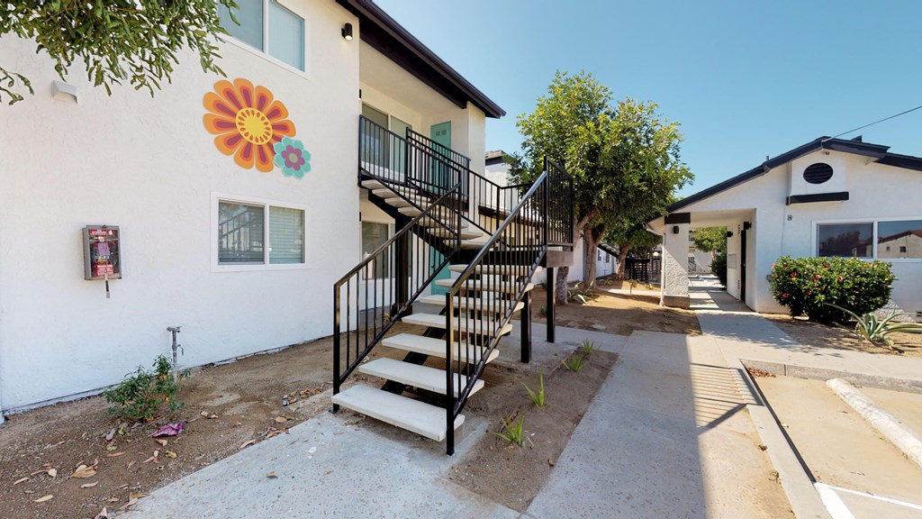 the outside of a building with stairs and a sidewalk
