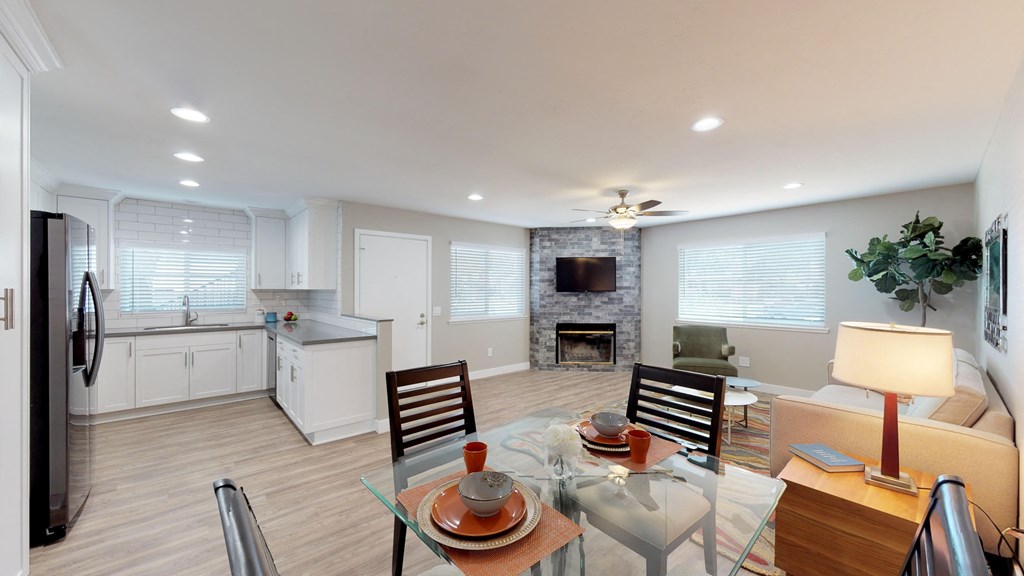 a living room and dining room with a glass table and chairs
