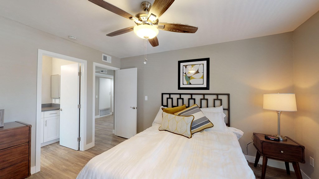 a bedroom with a large bed and a ceiling fan