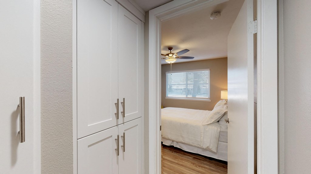 a bedroom with white cabinets and a ceiling fan