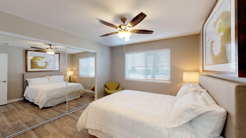 a bedroom with two beds and a ceiling fan