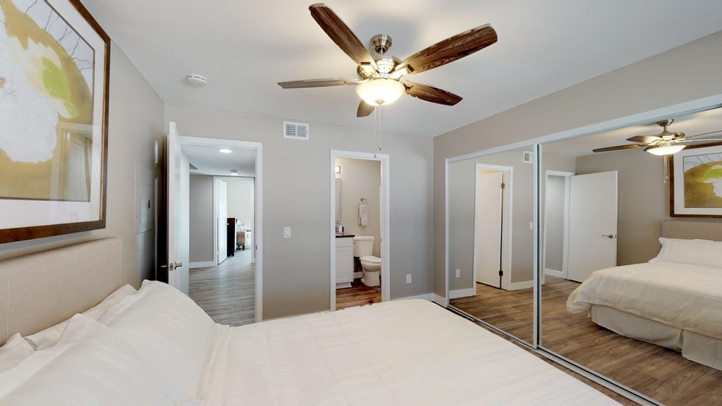 a bedroom with a large bed and a ceiling fan