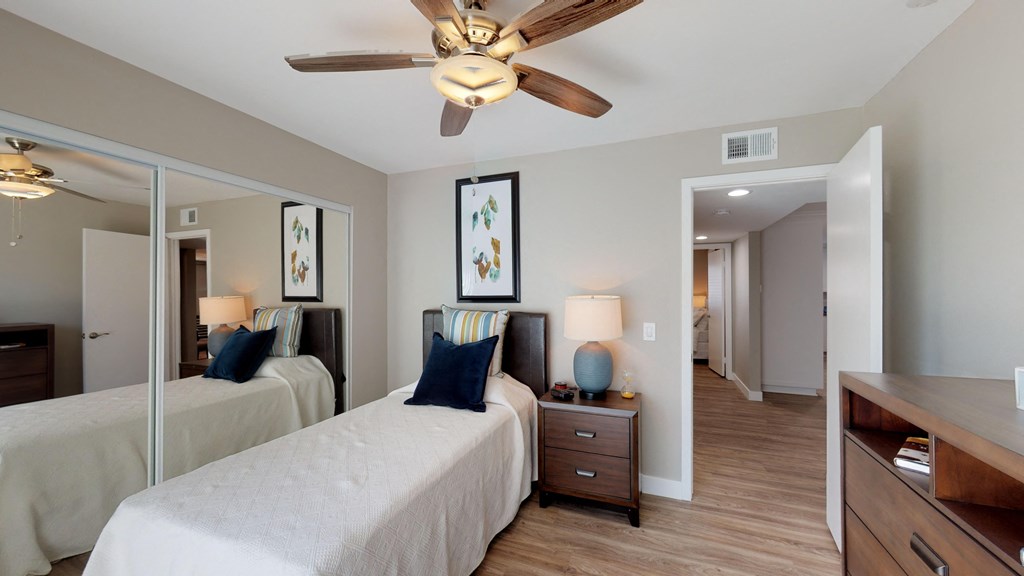 a bedroom with two beds and a ceiling fan