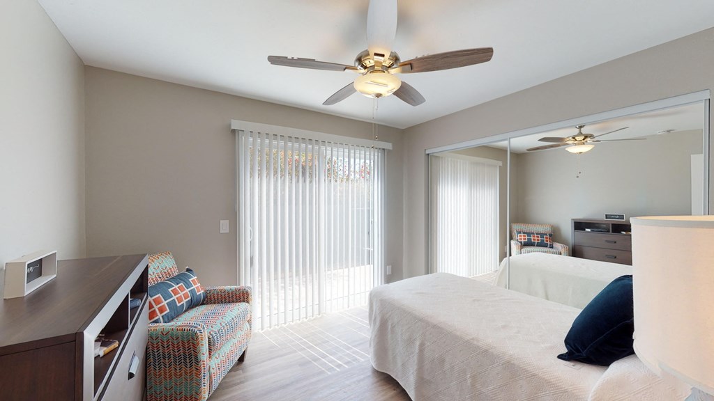 a bedroom with a large bed and a ceiling fan