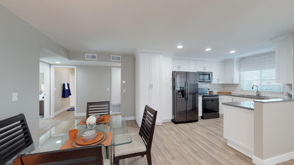 a kitchen and dining room with a glass table and chairs