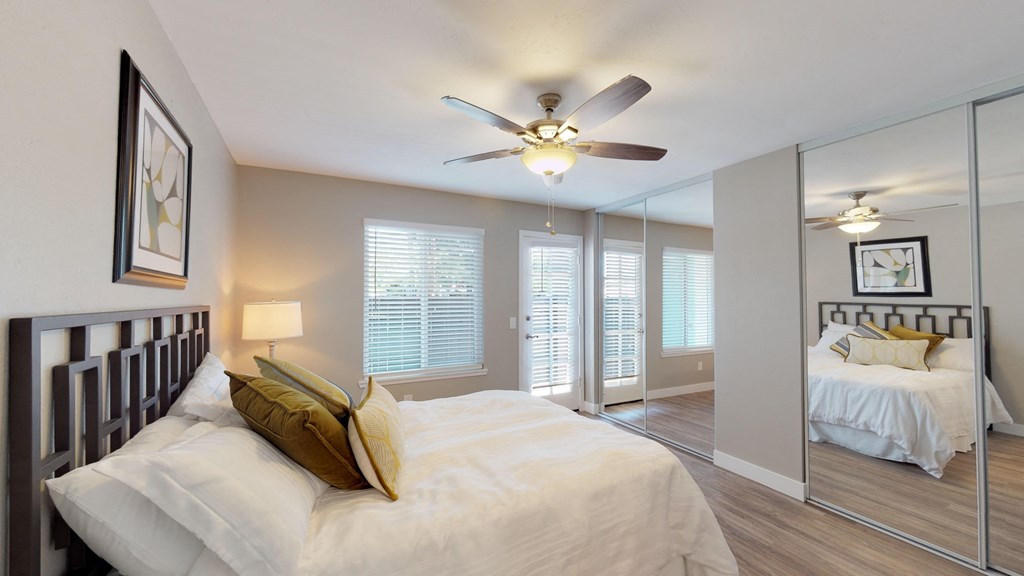 a bedroom with a large bed and a ceiling fan