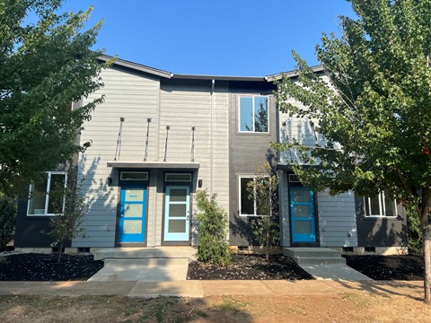 the front of a house with blue doors and windows