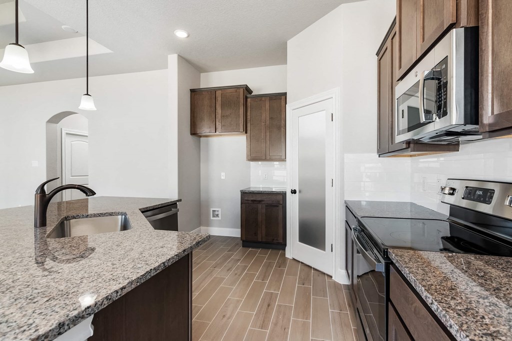 a kitchen with granite counter tops and black appliances