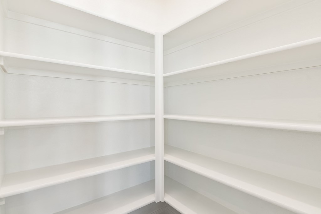 the corner of a white library with white shelves