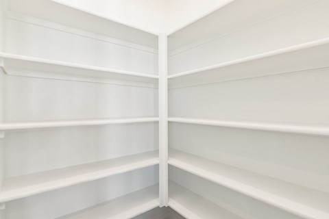 the corner of a white library with white shelves