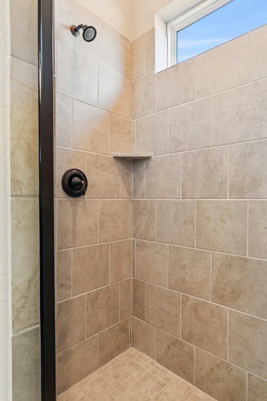 a bathroom with a shower and a window