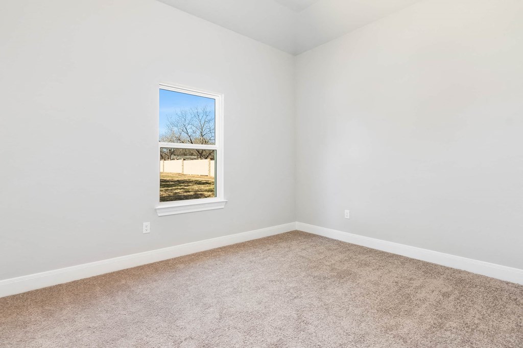 an empty room with a window and carpet